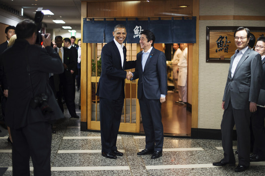 US President Barack Obama (L) shakes hands with Japanese Prime Minister Shinzo Abe before a private dinner at Sukiyabashi Jiro restaurant in Tokyo on April 23, 2014.   Obama landed in Tokyo on April 23 to launch an Asian tour dedicated to reinvigorating his policy of "rebalancing" US foreign policy towards a dynamic Asia.   Sukiyabashi Jiro's less-than-plush surroundings notwithstanding, it is the proud possessor of three Michelin stars, and people flock to pay a minimum $300 for 20 pieces of sushi chosen by the 88-year-old patron, Jiro Ono.  