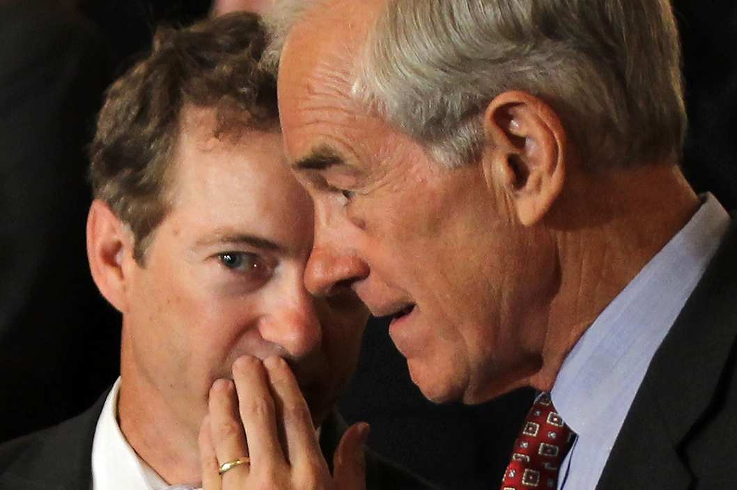 U.S. Sen. Rand Paul (R-KY) (L) talks to his father Rep. Ron Paul (R-TX) (R) during a news conference June 22, 2011 on Capitol Hill in Washington, DC. A number of Republican congressional members joined The Cut, Cap, Balance Pledge Coalition at the news conference "to oppose any debt ceiling increase unless a 'Cut, Cap and Balance' plan is passed."