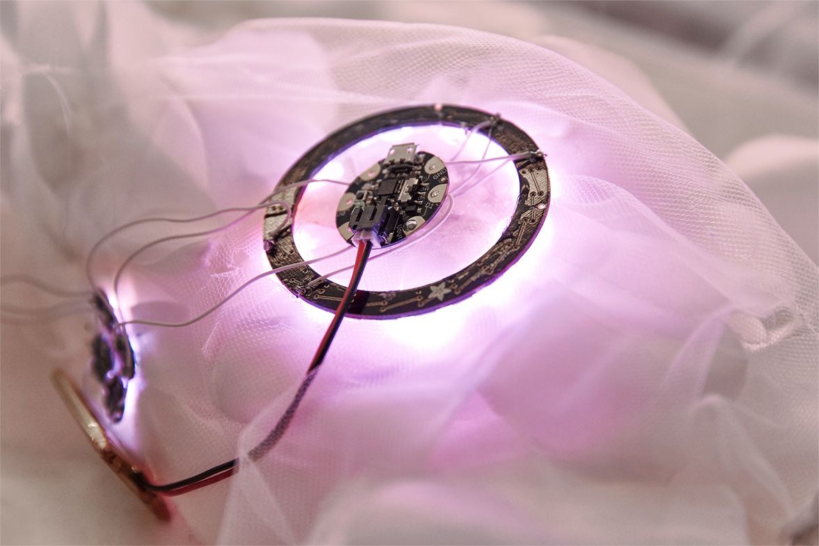 Fabric flower with LED light and circuitry underneath