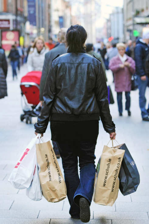A shopper carries bags of purchases along Henry Street in Dublin, Ireland, on Tuesday, Dec. 27, 2011. Ireland, which spent this year trying to prove to investors its finances weren't like euro partners closer to the Mediterranean, may have to pay Greek and Portuguese rates next year to return to the credit market. Photographer: Aidan Crawley/Bloomberg via Getty Images