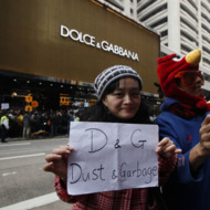 Protesters hold a placard outside a chain store of Dolce & Gabbana in Hong Kong Sunday, Jan. 8, 2012. Hundreds of Hong Kong protesters staged a protest outside an Italian luxury clothing chain store Dolce & Gabbana to demand an apology from the chain for allegedly preventing locals from taking photos of its storefront display. One of the security guards had earlier been reported as saying that only Mainland shoppers were allowed to take pictures of the store, even at the public road outside. (AP Photo/Kin Cheung)
