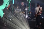 Damon Albarn (L) sings with drummer Dave Rowntree (C) and bassist Alex James (r) as the British alternative rock band Blur perform live on stage at the end of the BRIT Awards 2012 in London on February 21, 2012. 