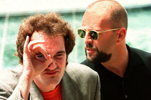 CANNES, FRANCE: US film director Quentin Tarantino (L) and compatriot actor Bruce Willis pose for photographers 21 May 1995 prior to the screening of their movie "Pulp Fiction" at the 47th Cannes Film Festival in France. (Photo credit should read PATRICK HERTZOG/AFP/Getty Images)