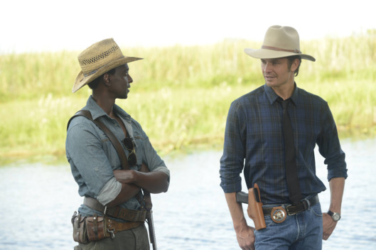 JUSTIFIED -- A Murder of Crowes -- Episode 501 (Airs Tuesday, January 7, 10:00 pm e/p) -- Pictured: (L-R) Edi Gathegi as Jean Baptiste, Timothy Olyphant as Deputy U.S. Marshal Raylan Givens -- CR: Guy D'Alama/FX
