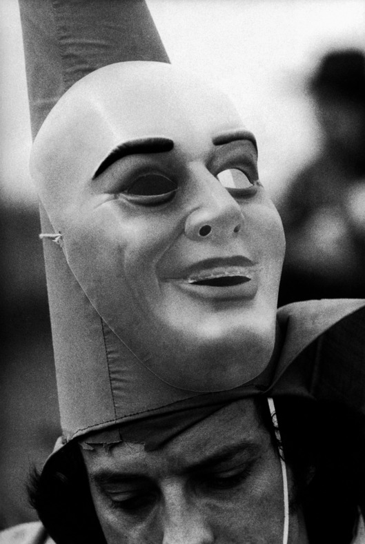ca. 1976, Mamou, Louisiana, USA --- The mask of reveler in a Cajun Marti Gras celebration is up around his pointed hat. Mamou, Louisiana. --- Image by ? Philip Gould/Corbis