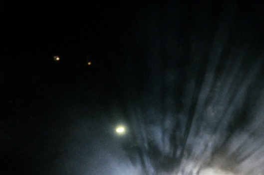 Robin Williams in the darkness next to a line of parked cars in a scene from the film 'The Fisher King', 1991.