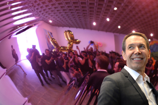 Artist Jeff Koons poses next to one of his sculptures during a press preview of "Jeff Koons: A Retrospective" a exhibition of his work at the Whitney Museum of American Art June 24, 2014. The show which spans the artist three decade career and will fill nearly the entire museum from June 27 through Oct. 19. AFP PHOTO / Timothy A. CLARY == MANDATORY MENTION OF THE ARTIST UPON PUBLICATION == (Photo credit should read TIMOTHY A. CLARY/AFP/Getty Images)