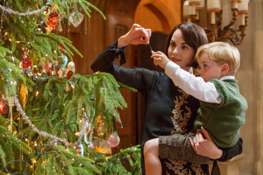 The Crawleys go to a shooting party at a castle in Northumberland and return to Downton for a joyful Christmas holiday. Shown from left to right: Michelle Dockery as Lady Mary and Oliver/Zac Barker as Master George Crawley.
