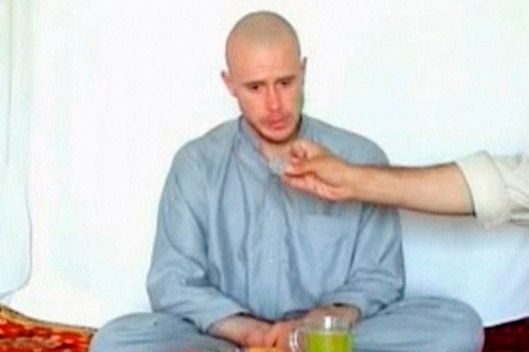 U.S. Army Private Bergdahl watches as one of his captors displays his identity tag at an unknown location in Afghanistan