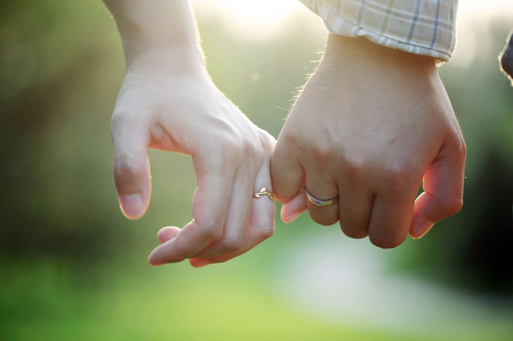 Young couple wearing rings hand in hand