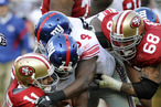 Alex Smith #11 of the San Francisco 49ers gets sacked by Osi Umenyiora #72 and Mathias Kiwanuka #94 of the New York Giants during an NFL football game at Candlestick Park November 13, 2011 in San Francisco, California. The 49ers won the game 27-20.