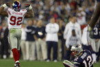 Quarterback Tom Brady gets up off the ground after being sacked by defensive end Michael Strahan