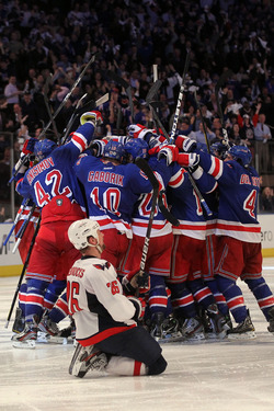 NEW YORK, NY - MAY 07: Marc Staal #18 of the New York Rangers celebrates with his teammates after scoring the winning goal in overtime against Braden Holtby #70 of the Washington Capitals as Matt Hendricks #26 of the Washington Capitals slides to the ice after Game Five of the Eastern Conference Semifinals during the 2012 NHL Stanley Cup Playoffs at Madison Square Garden on May 7, 2012 in New York City. The New York Rangers defeated the Washington Capitals in overtime 2-3. (Photo by Bruce Bennett/Getty Images)
