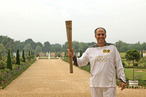 In this handout image provided by LOCOG, Torchbearer 009 Mark Levy holds the Flame in the grounds of Hampton Court Palace during the final day on July 27, 2012 in London, England.