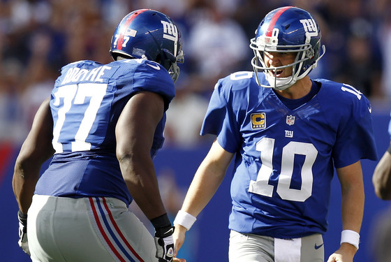 Eli Manning #10 and Kevin Boothe #77 of the New York Giants celebrate a touchdown against the Tampa Bay Buccaneers during a game at MetLife Stadium on September 16, 2012 in East Rutherford, New Jersey.