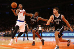 J.R. Smith #8 of the New York Knicks grabs a rebound as Joe Johnson #7, and Gerald Wallace #45 of the Brooklyn Nets defend during their game at Madison Square Garden on December 19, 2012 in New York City.