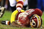 Robert Griffin III #10 of the Washington Redskins is injured as he fumbles a low snap in the fourth quarter against the Seattle Seahawks during the NFC Wild Card Playoff Game at FedExField on January 6, 2013 in Landover, Maryland.
