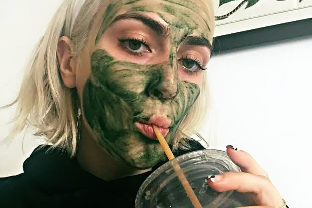 The author in her Chlorophyll mask drinking a green juice.