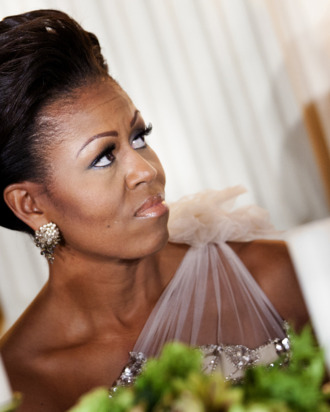 WASHINGTON - FEBRUARY 26: (AFP-OUT) First lady Michelle Obama listens to President Barack Obama speak in the State Dining Room of the White House February 26, 2012 in Washington, DC. President Obama and first lady Michelle Obama hosted 2012 Governors Dinner which coincides with the yearly meeting of the National Governors Association meeting in DC. (Photo by Brendan Smialowski/Getty Images)