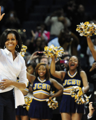 First lady Michelle Obama waves to the crowd as members of the Johnson C. Smith University cheerleaders cheer during the Let's Move! pre-game event during the CIAA Tournament at Time Warner Cable Arena on Friday, March 2, 2012 in Charlotte, North Carolina.