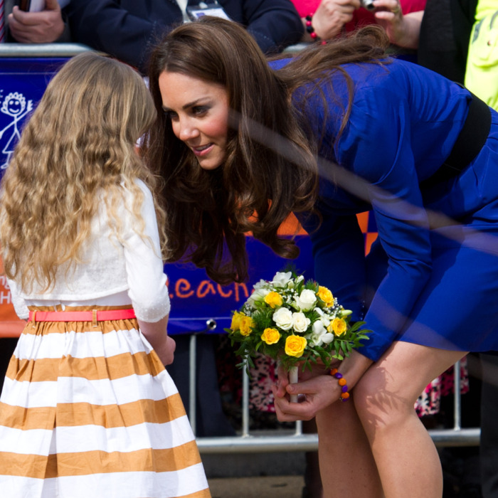 Kate accepts flowers from a child at the Treehouse Hospice in Ipswich, England.