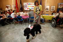 To kick off the Month of the Military Child, first lady Michelle Obama and her dog Bo participate in a pre-Easter celebration with military families and children at the Fisher House on Walter Reed National Military Medical Center April 4, 2012 in Bethesda, Maryland. The Fisher Houses are "comfort homes" that enable family members to be close to their military loved one during hospitalization for an unexpected illness, disease, or injury. Obama delivered Easter candies, visited with military children and gave away tickets to the White House Easter Egg Roll during the visit