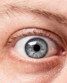 Closeup of a blue eye, of a Caucasian man, showing intricate details of the iris.