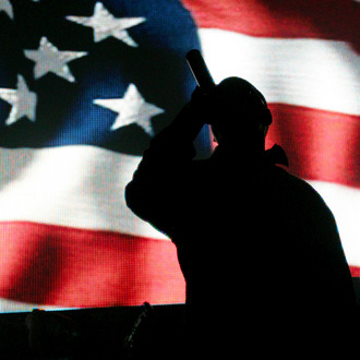 LAS VEGAS - DECEMBER 29: Rap artist Jay-Z is silhouetted against a video image of an American flag as he performs during a sold-out show at The Pearl concert theater at the Palms Casino Resort December 29, 2007 in Las Vegas, Nevada. (Photo by Ethan Miller/Getty Images)