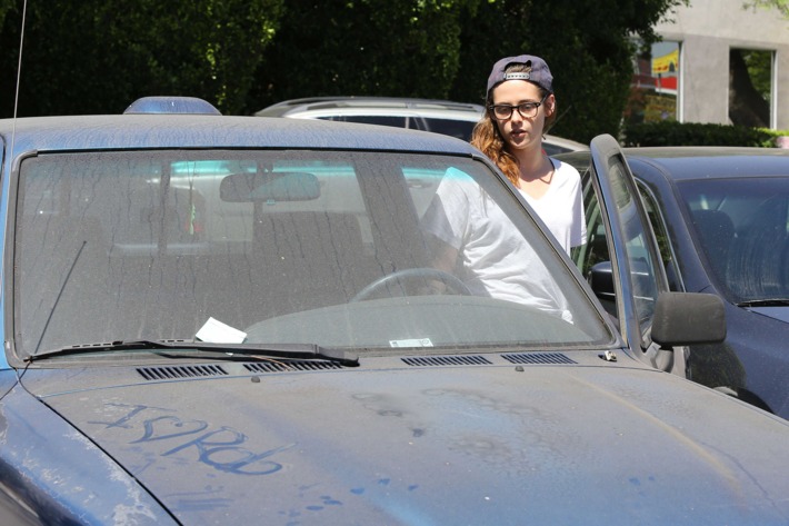 Kristen Stewart entering her truck, which has "I Love Rob" written across the hood.