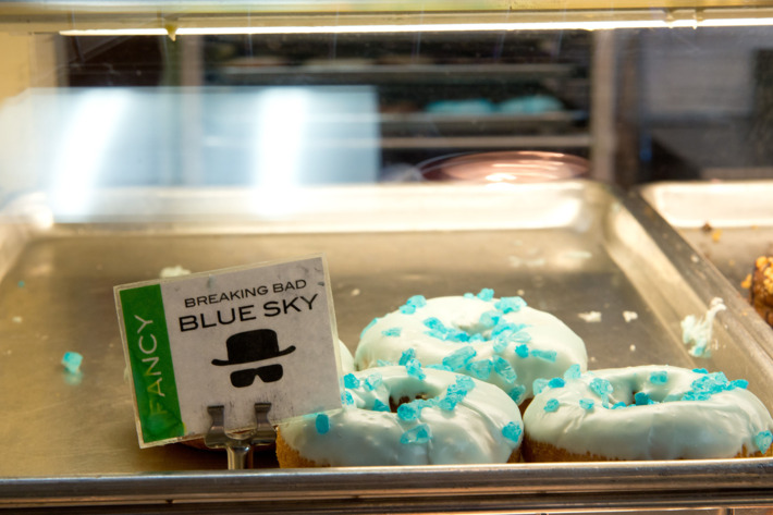 ALBUQUERQUE, NM - AUGUST 31: Several years ago a production assistant for AMC’s "Breaking Bad" stopped into Rebel Donuts at 2435 Wyoming NE, Albuquerque, New Mexico and asked them to make up several boxes of donuts topped with icing and blue rock candy to resemble Heisenberg’s blue meth. The donuts were taken to the shooting location and were an instant hit. They are now a regular item in their shop. A photograph of Aaron Paul holding a box of "Breaking Bad" Blue Sky donuts now hangs on the wall of the shop. (Photo by Steve Snowden / Getty Images)