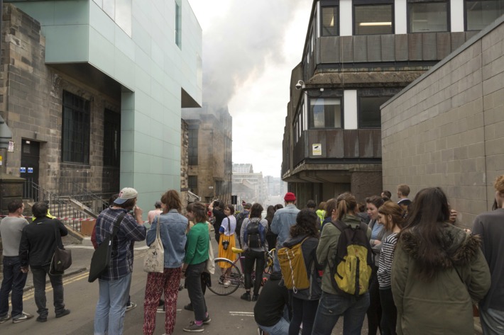 Glasgow, United Kingdom. 23rd May 2014 -- Larger crowds start to gather from neighbouring offices. -- The Charles Rennie Mackintosh designed Glasgow School of art is currently on fire with emergency services crews in attendance.