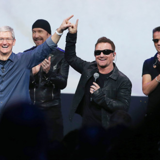 CUPERTINO, CA - SEPTEMBER 09: Apple CEO Tim Cook (L) greets the crowd with U2 singer Bono (2nd R) as The Edge (2nd L) and Larry Mullen Jr look on during an Apple special event at the Flint Center for the Performing Arts on September 9, 2014 in Cupertino, California. Apple unveiled the Apple Watch wearable tech and two new iPhones, the iPhone 6 and iPhone 6 Plus. (Photo by Justin Sullivan/Getty Images)