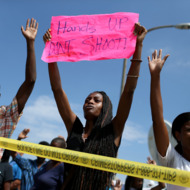 ST. LOUIS, MO - AUGUST 19: People raise their arms while chanting, "Hands up, Don't Shoot", as they stand nearby to where St. Louis police say officers shot and killed a 23-year-old man who was wielding a knife and refused to drop it on August 19, 2014 in St Louis, Missouri. Violent outbreaks have taken place in Ferguson since the shooting death of unarmed teenager Michael Brown by a Ferguson police officer on August 9. (Photo by Joe Raedle/Getty Images)