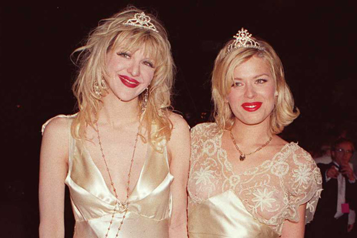 Dressed in similar, silver evening gowns and tiaras, American musician and actress Courtney Love (left) and British actress and model Amanda de Cadenet pose together at a Vanity Fair Oscar party at the Four Seasons, Los Angeles, California, March 27, 1995. (Photo By Tammie Arroyo/Getty Images)