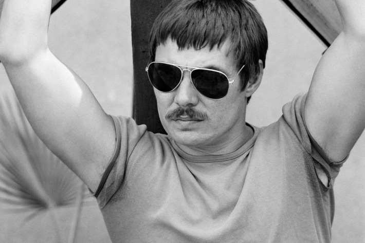 05 May 1979, New York City, New York State, USA --- American artist Chris Burden, working in performance, sculpture, and installation art posing in front of The Big Wheel under construction in 1979.The Wheel is currently on display at The New Museum in New York as part of: "Extreme Measures", a retrospective of Chris Burdens work. --- Image by ? Kenneth Johansson/Corbis