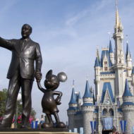 A statue of Walt Disney and Mickey Mouse stands in front of
