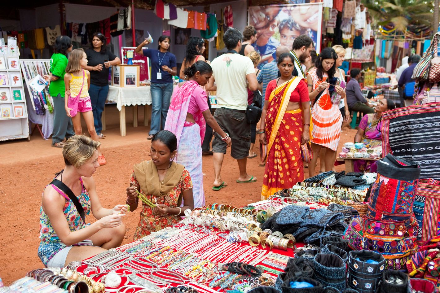 India, Goa State, Anjuna, tourists shopping at market stall