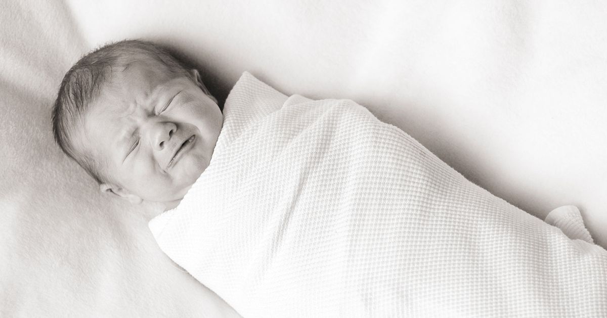 Crying, Swaddled Newborn Laying on Blanket, Black and White