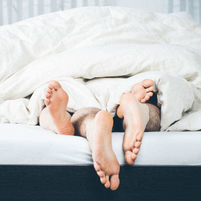 Legs entwined bed.