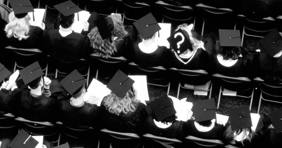 University students in graduation ceremony, question mark on one hat